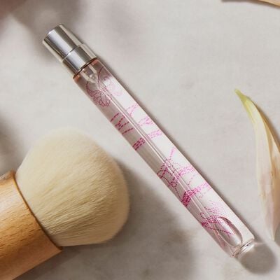 Thymes Kimono Rose Eau de Parfum Spray Pen flat lay next to make up brush